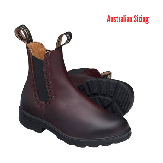 Burgundy leather Chelsea boot with black elastic side panel, pull tabs, and lug outsole, shown with one boot upright and one sole-up