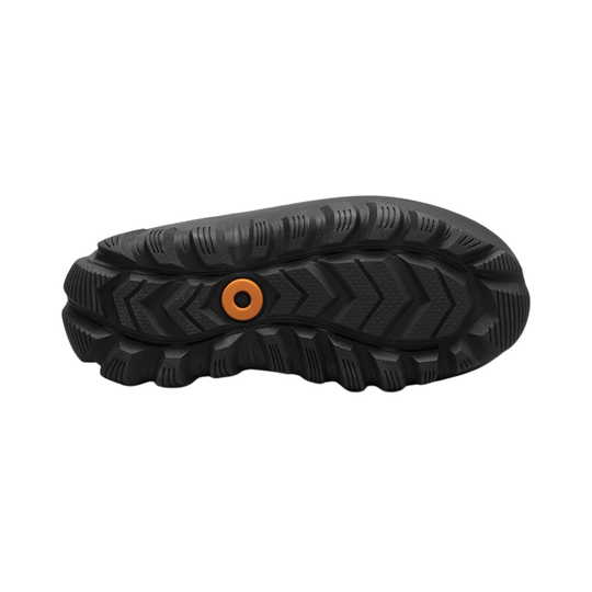 Black boot outsole with deep tread and an orange circular insert