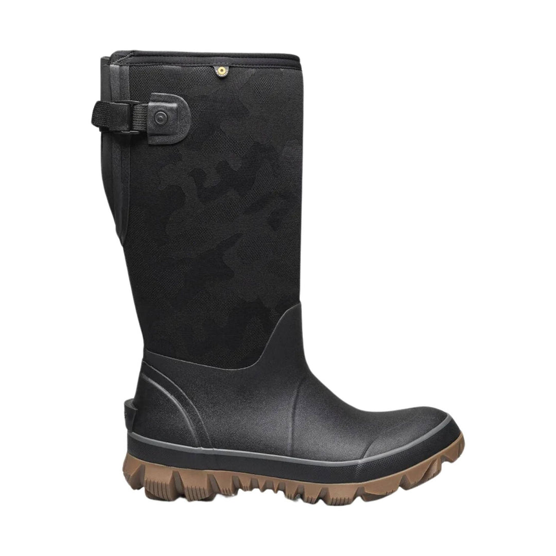 Black tall waterproof winter boot with a brown lug sole and side adjustment strap