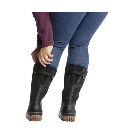 Black mid-calf rain boots with adjustable calf straps and tan lug soles