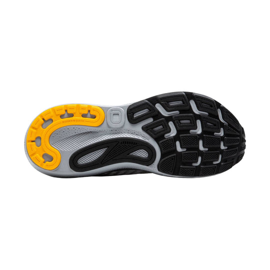 Running shoe outsole with yellow heel cushioning and black traction pods on a gray midsole