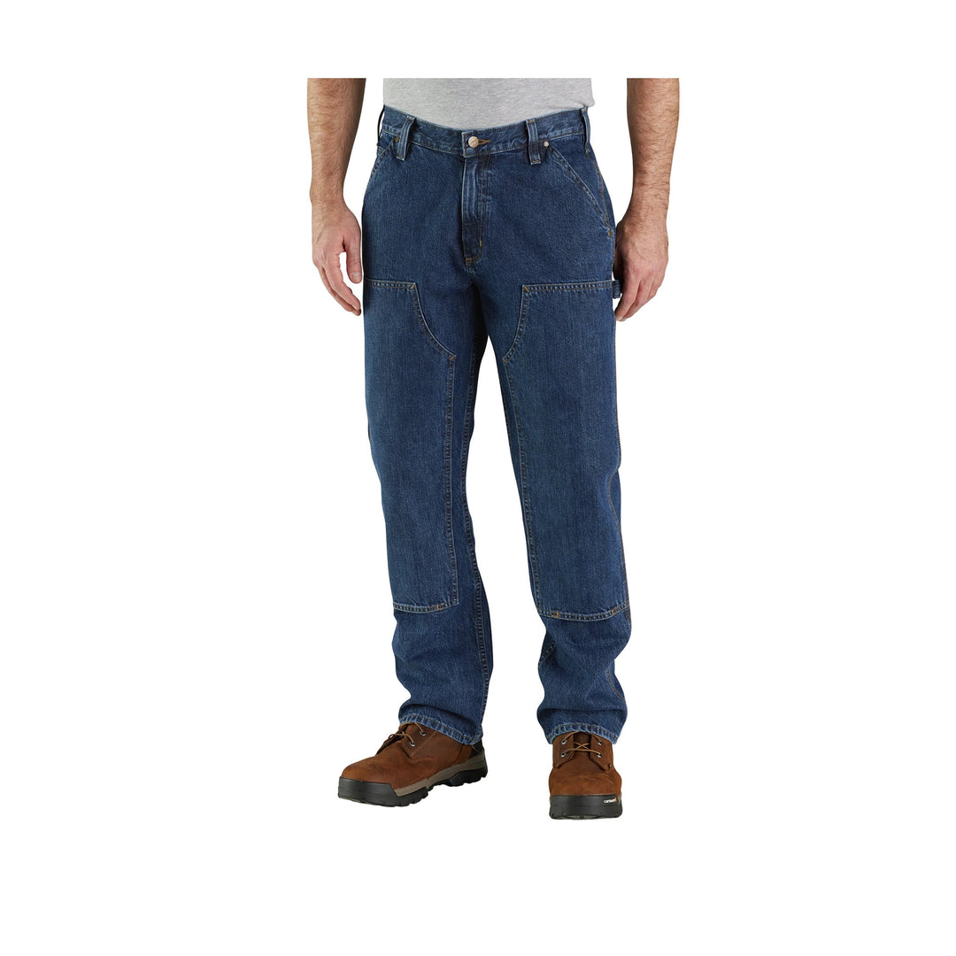 Loose-fit blue denim work pants with double front knees and brown work boots