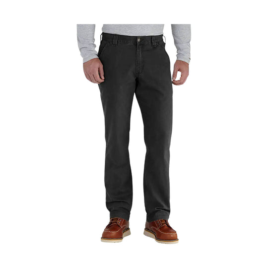 Black relaxed-fit pants with a straight leg, worn with a gray long-sleeve shirt and brown work shoes