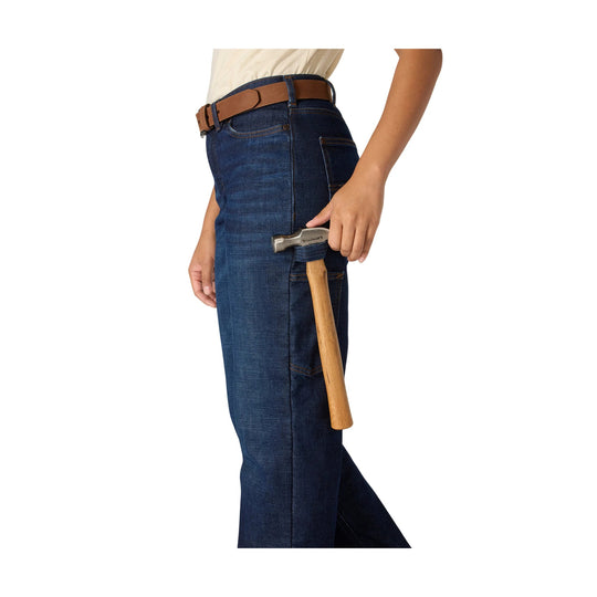 Side-view dark blue carpenter jeans with utility pockets and a hammer in the pocket loop