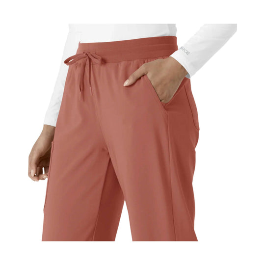 Coral scrub pants with drawstring waist, side pockets, and boot-cut legs