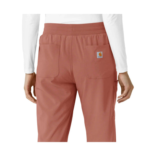 Rust-colored scrub pants with back patch pockets and a small Carhartt logo patch