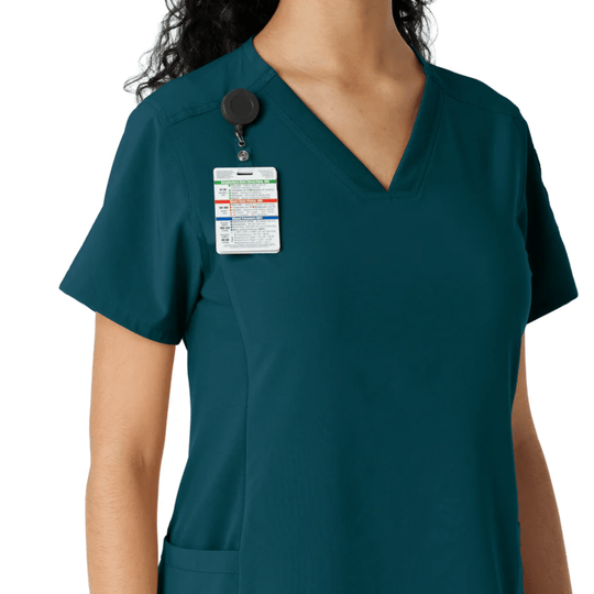 Teal short-sleeve scrub top with V-neck, chest badge reel, and hanging ID badge
