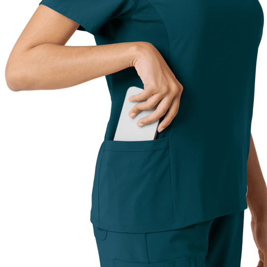 Teal scrub top with side pocket holding a white phone