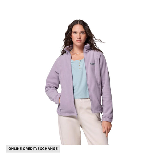 Light purple full-zip fleece jacket over a light blue henley top and cream pants