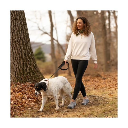 Gray slip-on sneakers worn on a woman walking a dog outdoors