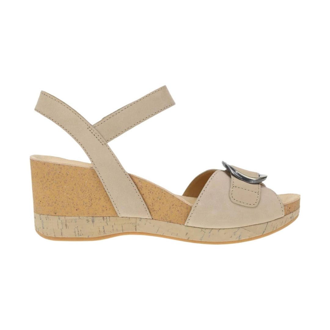 Beige wedge sandal with ankle strap, cork-look heel, and metallic buckle detail