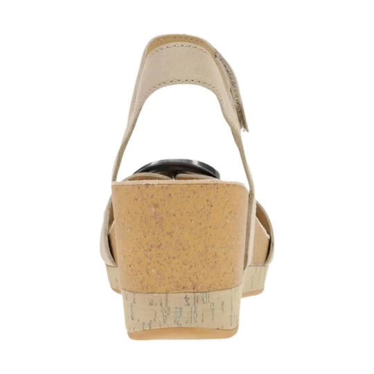 Beige wedge sandal shown from the back with an ankle strap and cork-textured heel