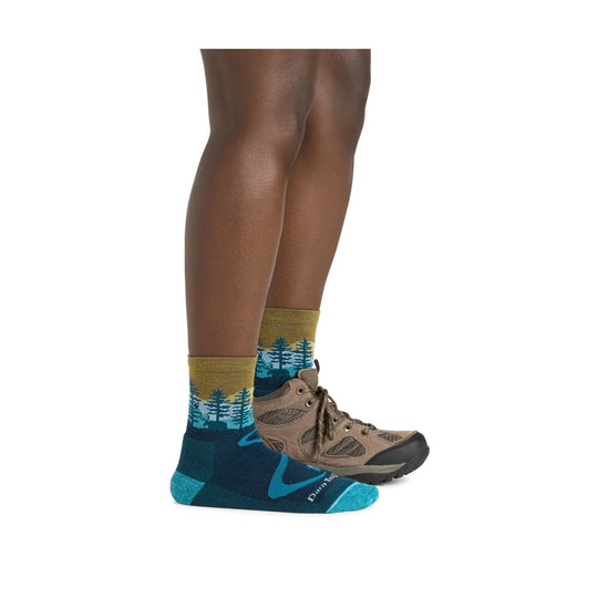 Teal hiking socks with forest pattern, worn with brown hiking boots