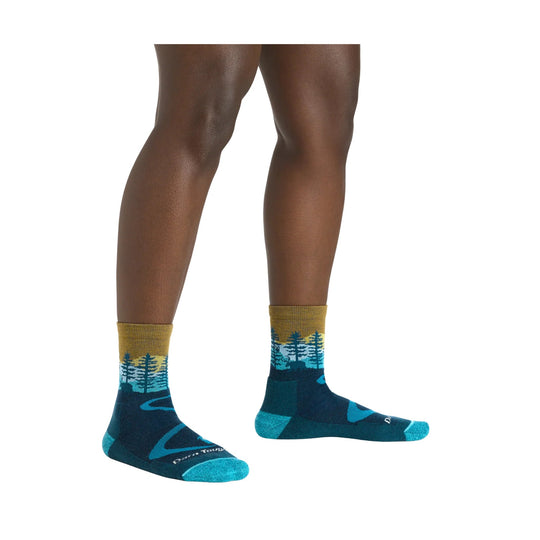 Pair of dark teal hiking socks with turquoise toes and forest pattern cuffs