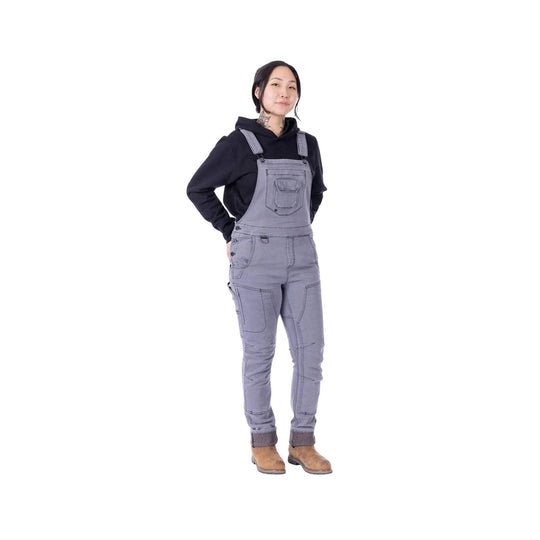 Grey denim overalls with front chest pocket worn over a black hoodie and tan boots
