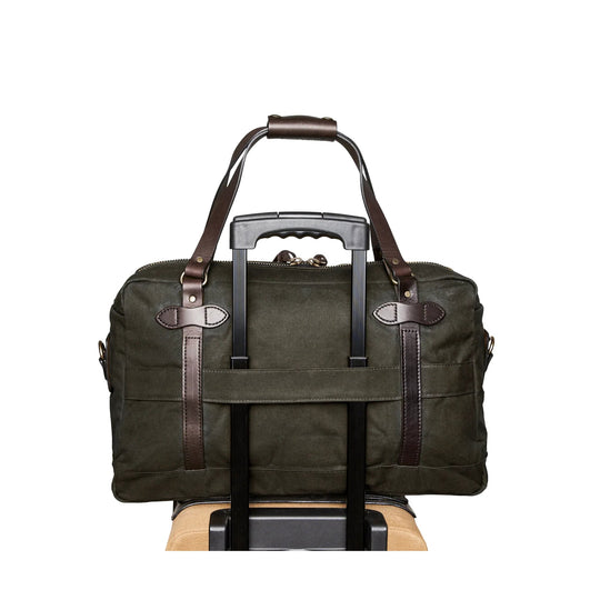 Olive canvas duffle bag with brown leather straps on a luggage handle