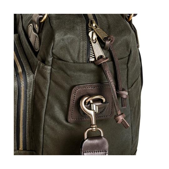 Olive canvas duffle bag with leather trim, brass zippers, and front buckle hardware