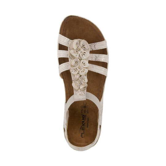 White slingback sandal with floral cutout straps and a brown footbed, seen from above