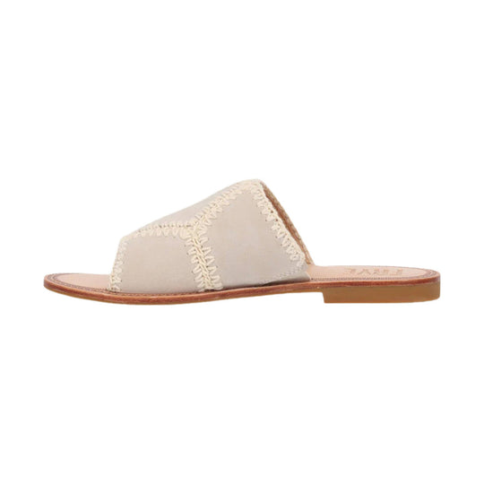 Ivory slide sandal with stitched suede-like upper and tan flat sole, side view
