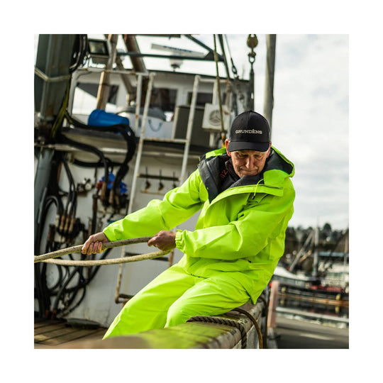 Neon yellow waterproof jacket and bib pants on a man working on a boat