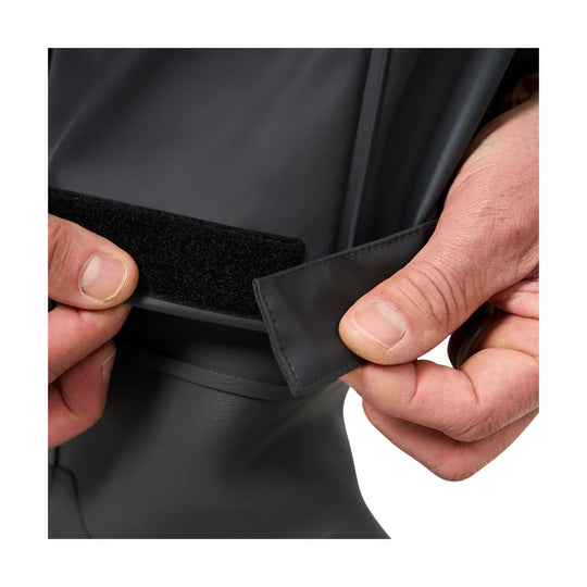 Black waterproof bib pants with a hook-and-loop waist closure being fastened