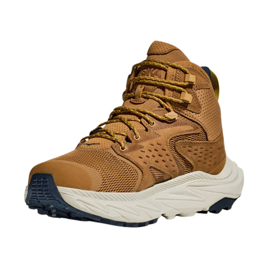 Tan mid-top hiking boot with yellow laces, mesh panels, and a white cushioned sole