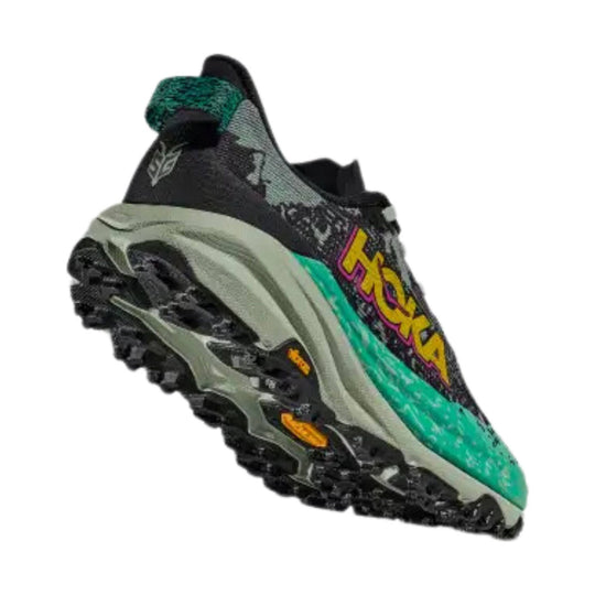 Black trail running shoe with teal accents, chunky lugged sole, and large side lettering