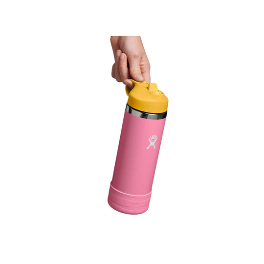 Pink insulated water bottle with yellow straw cap and carry loop, shown held in a hand