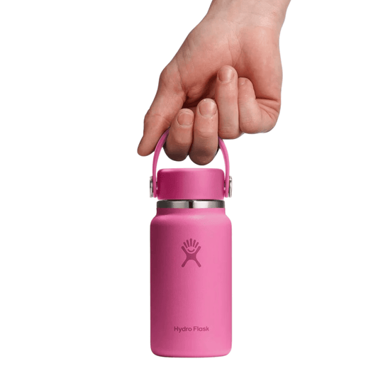 Pink water bottle with a carry handle, shown being held by a hand