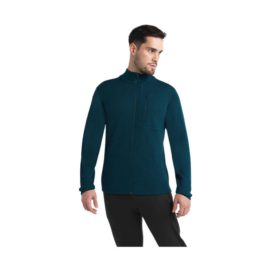 Men's teal full-zip fleece jacket with a stand collar, chest zip pocket, and side pockets