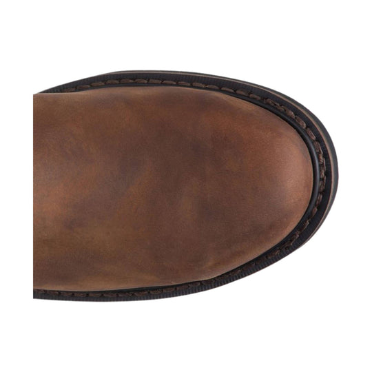 Brown leather boot toe with dark stitched welt and rounded sole edge