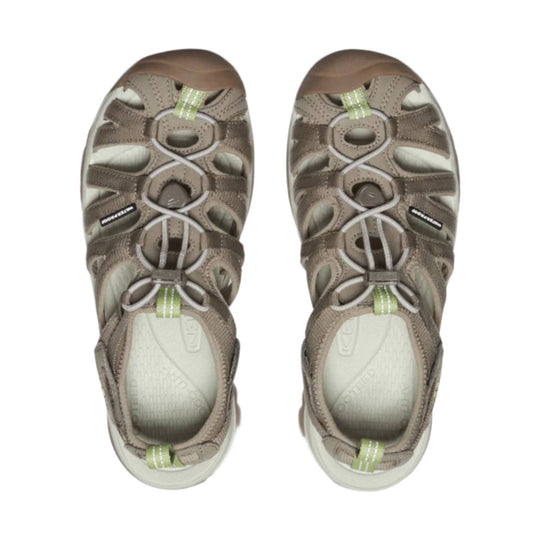 Pair of taupe closed-toe hiking sandals with bungee laces, side cutouts, and green heel tabs