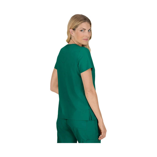 Woman wearing a teal scrub top and matching pants, shown from the back and slightly turned
