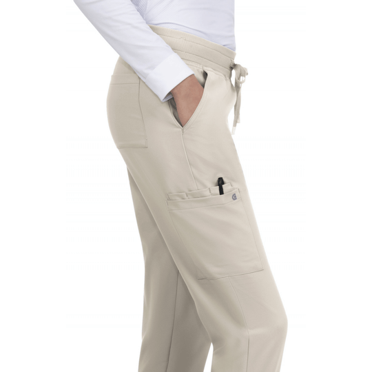 Beige scrub jogger pants with elastic waist, drawstring, and large side cargo pocket