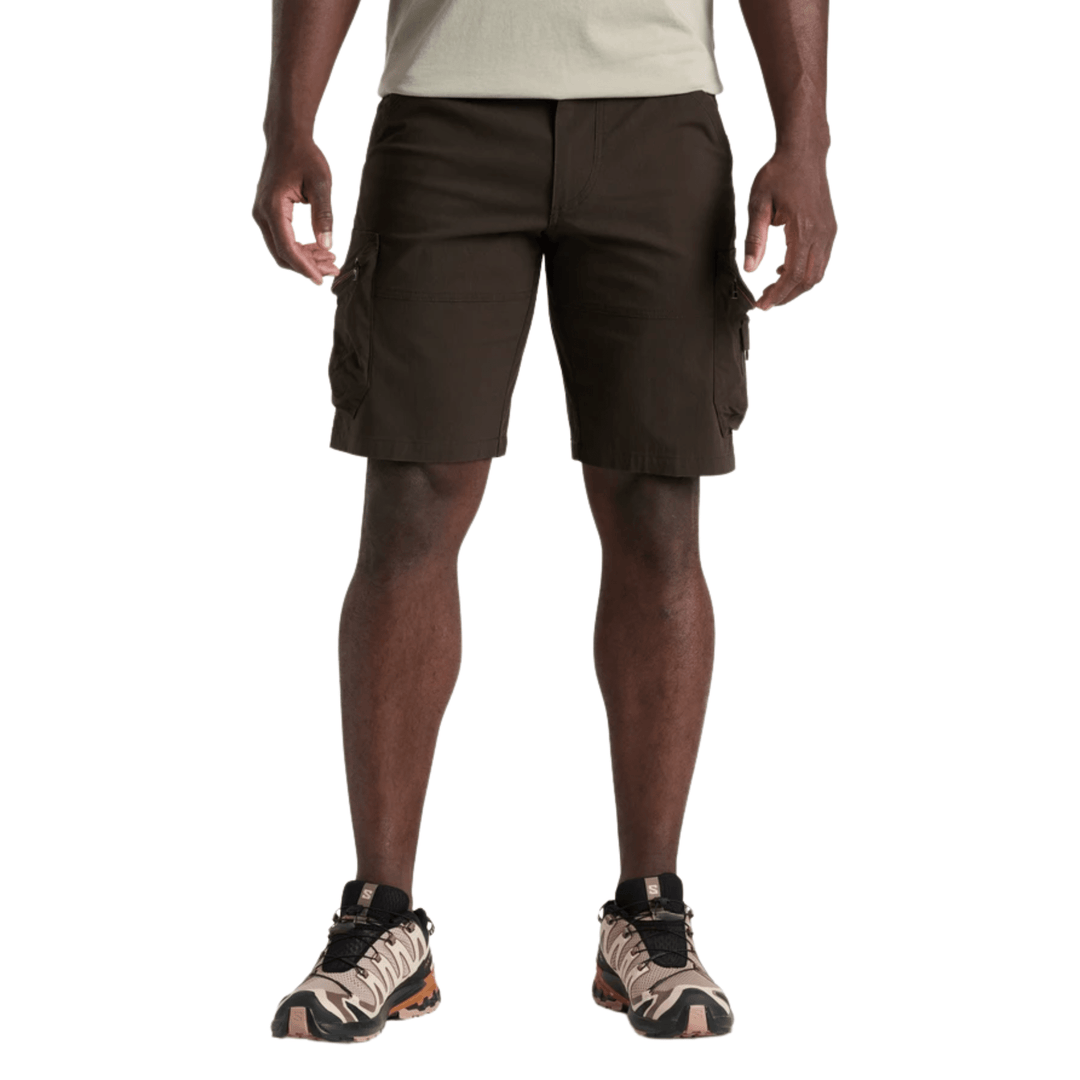 Brown cargo shorts with side pockets, shown on a model with a light shirt and hiking shoes.