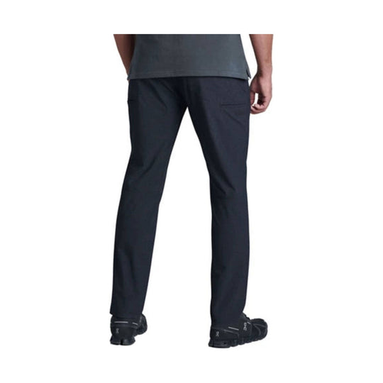 Back view of dark straight-leg pants with side pocket and black shoes
