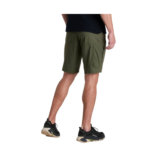 Olive cargo shorts worn with a black shirt and black trail shoes, back view