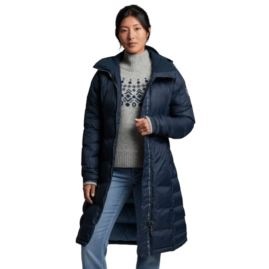 Long navy quilted hooded parka worn over a gray patterned sweater and jeans