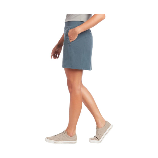 Blue-gray athletic skort with side pocket and built-in shorts, worn with beige sneakers