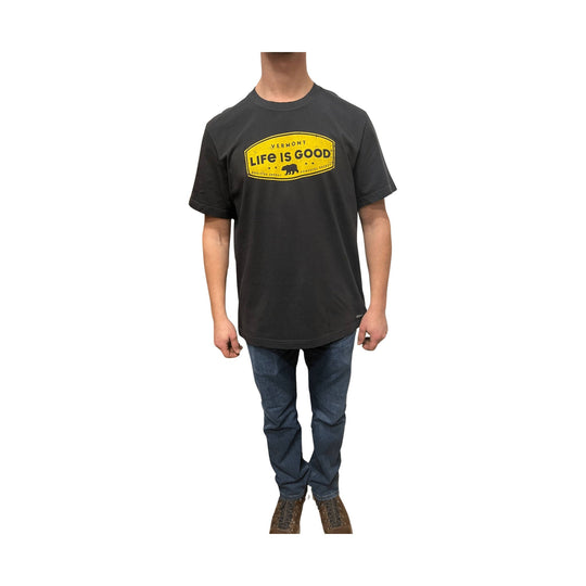 Black short-sleeve T-shirt with a yellow bear-shaped chest graphic and jeans on a model