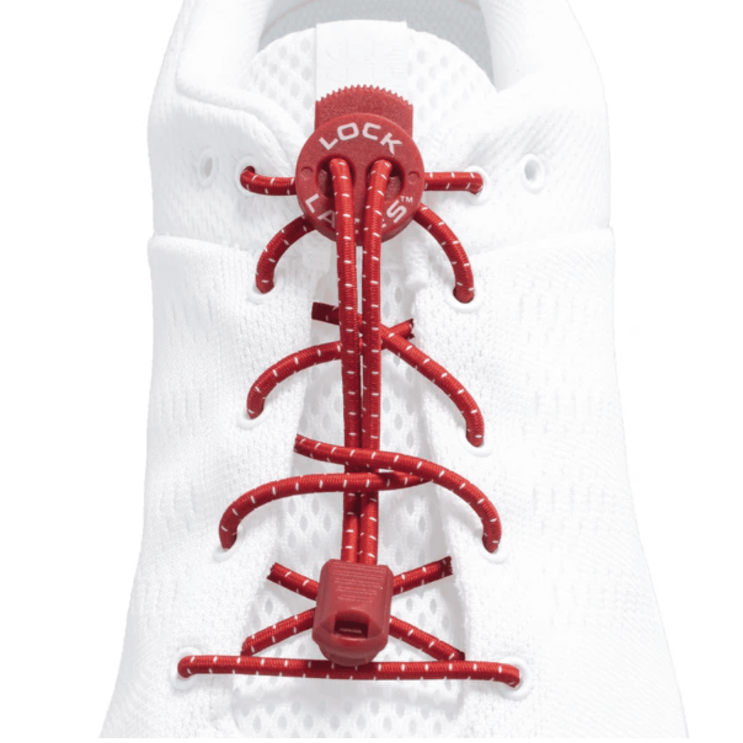 Red bungee shoelaces with a round locking toggle on a white shoe tongue