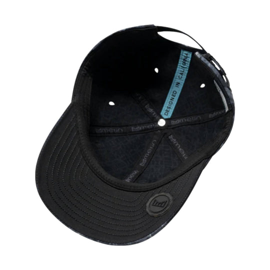 Black fitted baseball cap shown inside out with a blue "Designed in California" tag