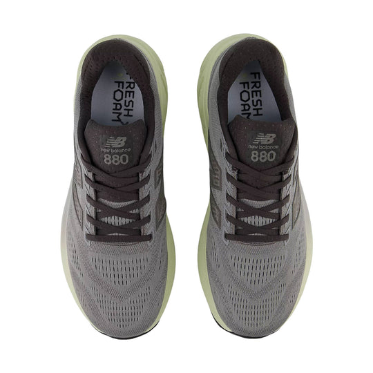 Pair of gray running shoes with dark brown laces and lime-green soles, top view