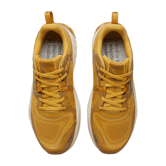 Mustard yellow trail running shoes with mesh uppers, bungee laces, and visible "HIERRO" branding