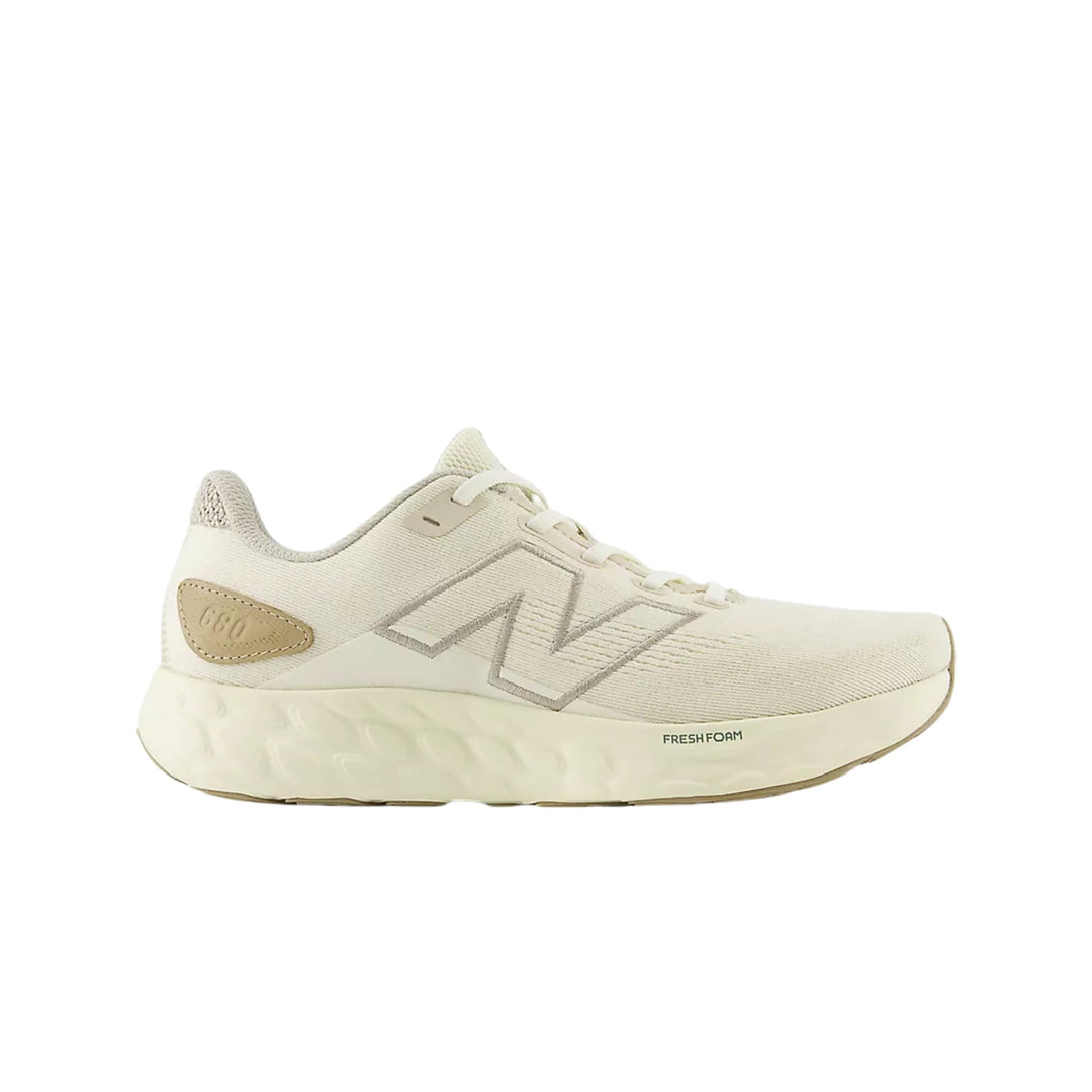 Cream low-top running shoe with knit upper, large side logo, and thick foam midsole