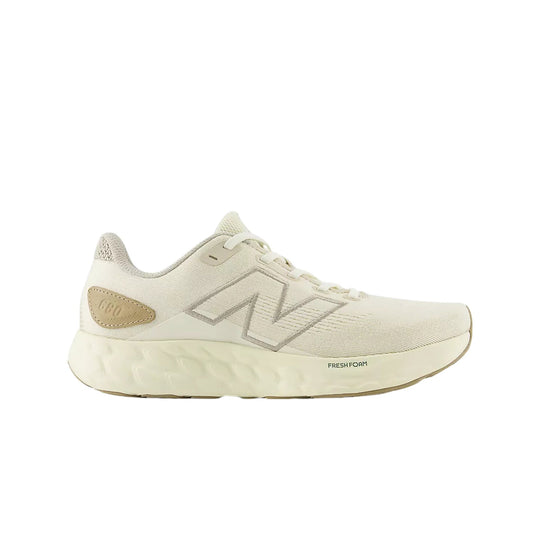 Cream low-top running shoe with knit upper, large side logo, and thick foam midsole