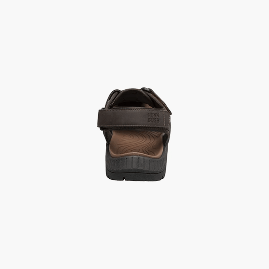 Brown closed-toe sandal viewed from the back with a wide heel strap and textured sole