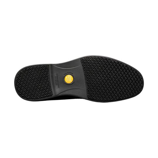 Black work shoe outsole with diamond tread and a yellow center plug