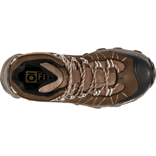 Brown mid hiking boot with black toe cap, lug sole, and tan-and-white laces, viewed from above.