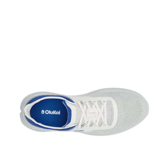 Top view of a white knit sneaker with white laces, blue lining, and OluKai branding on the insole